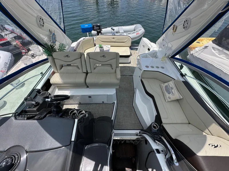 Slide: The Image of Interior of 2020 Monterey 355 Sport Yacht with seating and helm, docked by water. - 45