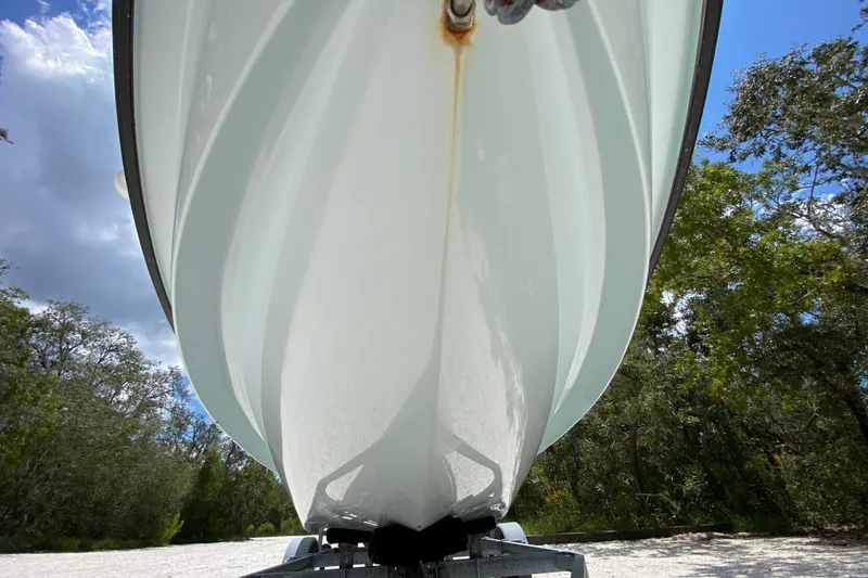 Slide: The Image of 2019 Cayo Boatworks 173 hull underside, parked on trailer, surrounded by trees and blue sky. - 17