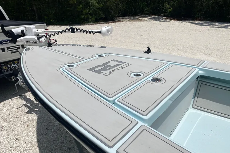 Slide: The Image of 2019 Cayo Boatworks 173 with Minn Kota motor, parked on gravel near trees. - 19