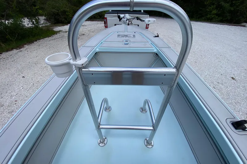 Slide: The Image of 2019 Cayo Boatworks 173 interior with metal railing and cup holder on a gravel path. - 35