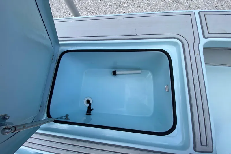 Slide: The Image of Open storage compartment on 2019 Cayo Boatworks 173, featuring a clean, light blue interior. - 44