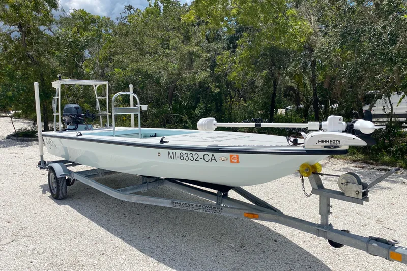 Slide: The Image of 2019 Cayo Boatworks 173 on trailer, surrounded by trees, featuring Minn Kota trolling motor. - 7