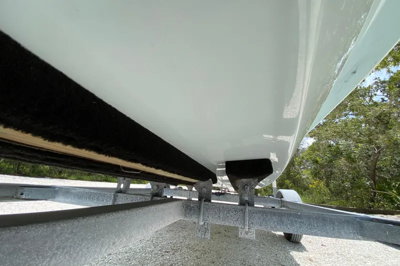 Slide: The Image of 2019 Cayo Boatworks 173 on trailer, underside view, surrounded by trees. - 9