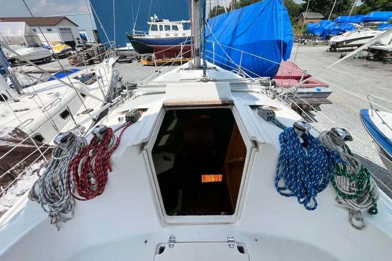 Slide: The Image of 1995 Hunter 29.5 sailboat deck with ropes, docked in a marina. - 10