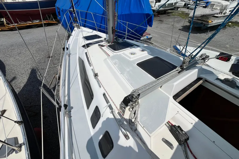 Slide: The Image of 1995 Hunter 29.5 sailboat deck with rigging and hatches, docked in a marina. - 11