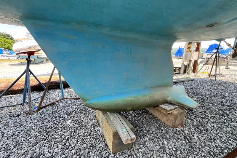Slide: The Image of Keel of a 1995 Hunter 29.5 sailboat on wooden supports in a boatyard. - 2