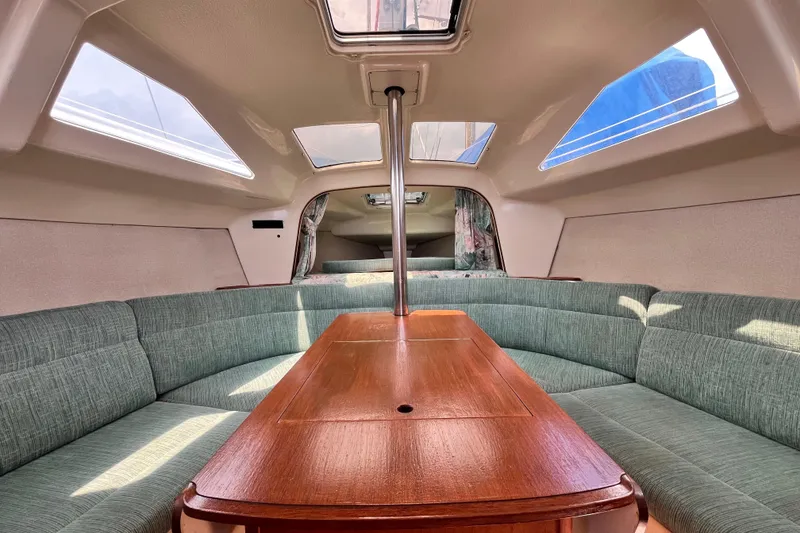 Slide: The Image of Interior of a 1995 Hunter 29.5 sailboat with green seating and wooden table. - 34