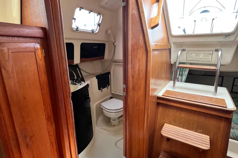 Slide: The Image of Interior of 1995 Hunter 29.5 sailboat featuring wooden cabinetry and compact bathroom. - 37