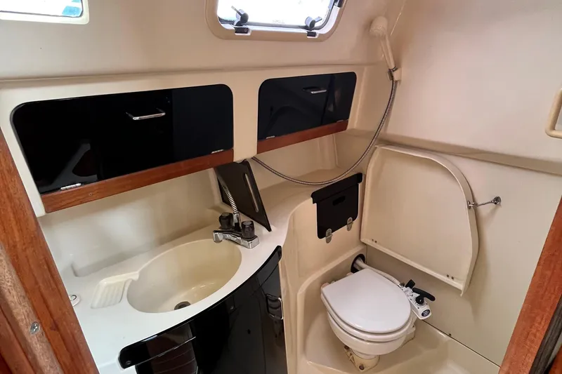 Slide: The Image of Interior of 1995 Hunter 29.5 sailboat bathroom with sink, toilet, and storage cabinets. - 38