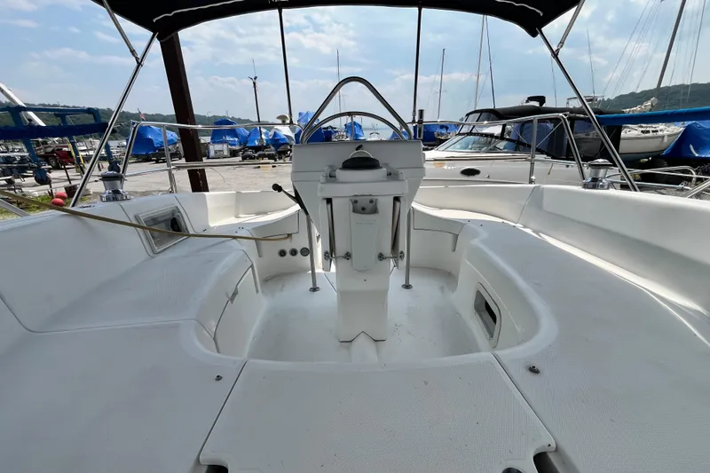 Slide: The Image of 1995 Hunter 29.5 sailboat cockpit with steering wheel, docked in marina. - 7