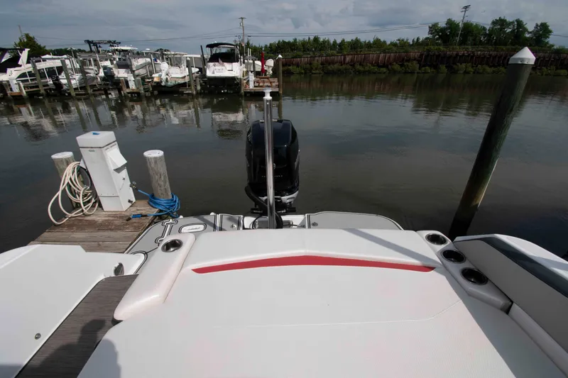 Slide: The Image of 2022 Four Winns HD8 boat docked at marina, rear view with motor and deck. - 10