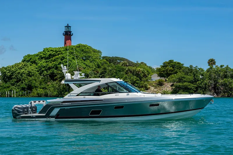 The Image of 2019 Formula 430 Super Sport Crossover yacht cruising near a lush island with a lighthouse. - 0
