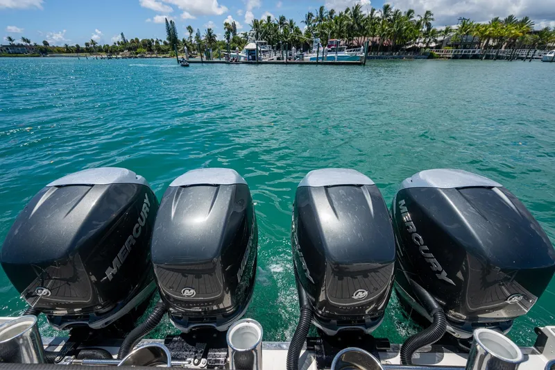 Slide: The Image of Four Mercury outboard engines on a 2019 Formula 430 Super Sport Crossover, docked by a tropical shoreline. - 57
