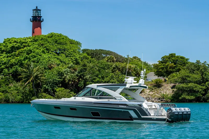 Slide: The Image of 2019 Formula 430 Super Sport Crossover yacht near a lush island and lighthouse. - 68