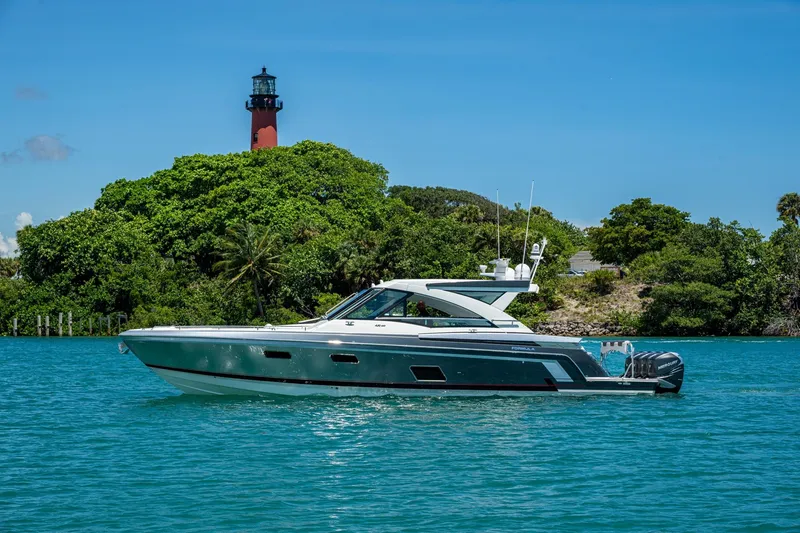 Slide: The Image of 2019 Formula 430 Super Sport Crossover yacht cruising near a lush island with a lighthouse. - 72