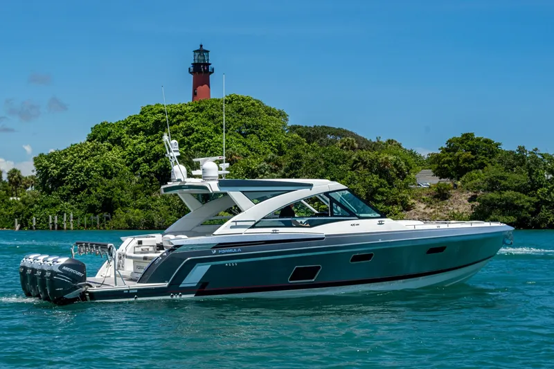 Slide: The Image of 2019 Formula 430 Super Sport Crossover yacht cruising near a lush island and lighthouse. - 80