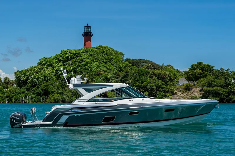 Slide: The Image of 2019 Formula 430 Super Sport Crossover yacht cruising near a lush island with a lighthouse. - 83