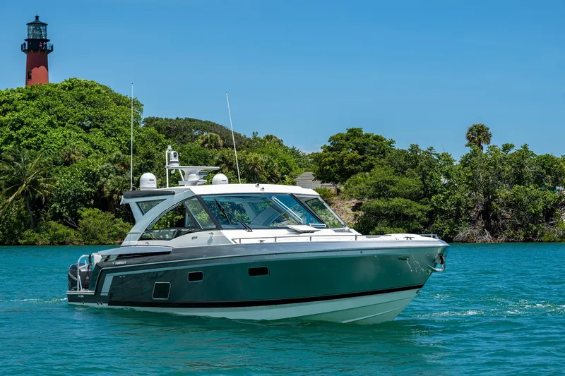 Slide: The Image of 2019 Formula 430 Super Sport Crossover yacht cruising near lush greenery and lighthouse. - 87