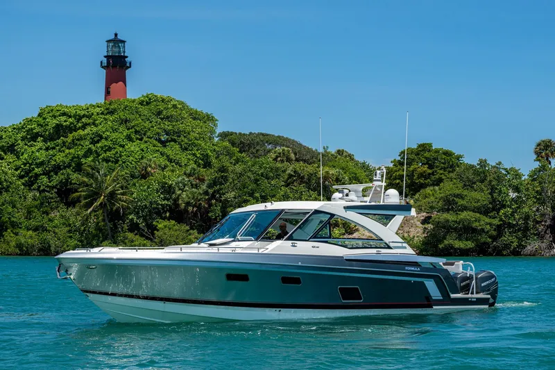 Slide: The Image of 2019 Formula 430 Super Sport Crossover yacht cruising near a lush island with a lighthouse. - 90