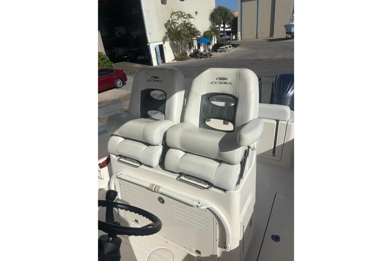 Slide: The Image of 2022 Cobia 280 Center Console boat seats in a marina setting. - 10