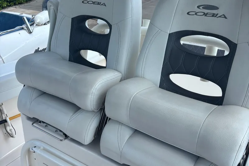 Slide: The Image of 2022 Cobia 280 Center Console boat seats with logo, featuring plush gray upholstery. - 2