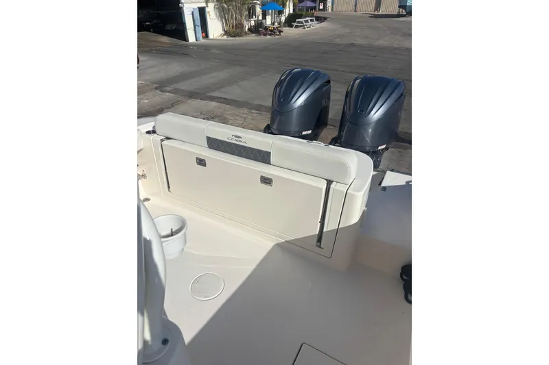 Slide: The Image of 2022 Cobia 280 Center Console boat with dual outboard motors, docked at marina. - 9