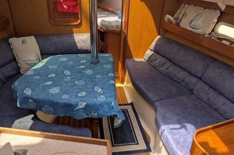 Slide: The Image of Interior of a 1998 Hunter 34 sailboat with blue seating and nautical decor. - 13