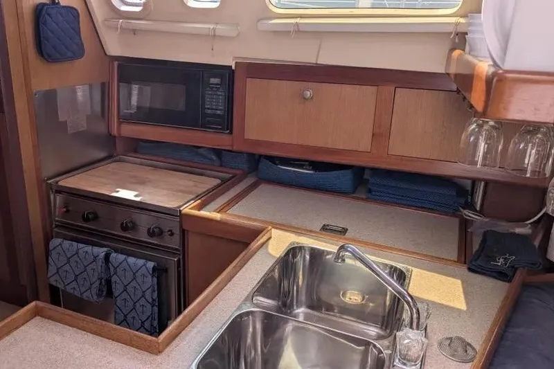 Slide: The Image of 1998 Hunter 34 yacht kitchen with stove, microwave, and sink. - 14