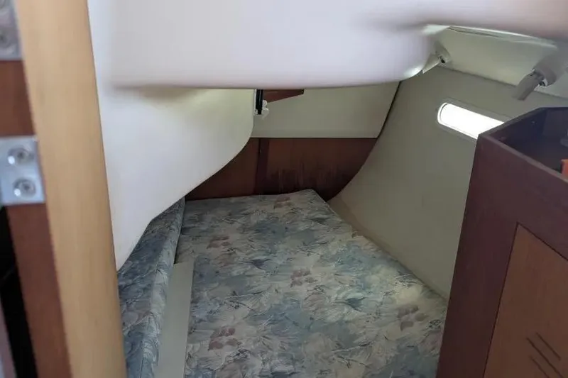 Slide: The Image of Interior cabin of a 1998 Hunter 34 sailboat with a floral-patterned bed. - 15
