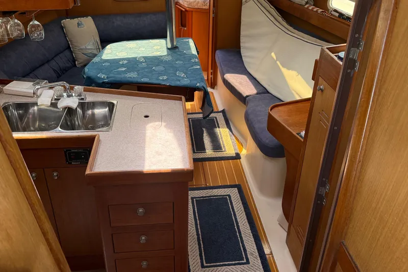 Slide: The Image of Interior of a 1998 Hunter 34 sailboat with cozy seating and compact kitchen area. - 18