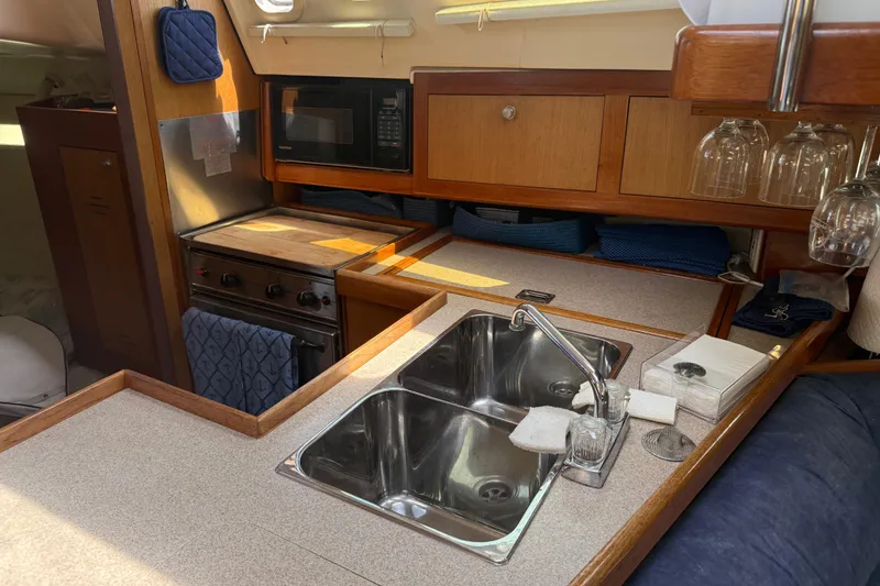 Slide: The Image of Compact kitchen in a 1998 Hunter 34 sailboat with sink, stove, and microwave. - 24
