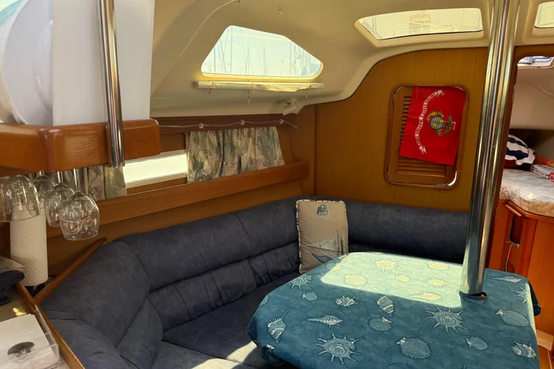 Slide: The Image of Cozy interior of a 1998 Hunter 34 sailboat with blue seating and nautical decor. - 27