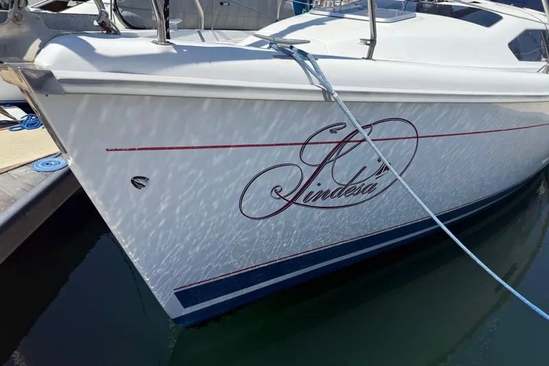 Slide: The Image of 1998 Hunter 34 sailboat docked, featuring elegant script and sleek design. - 3