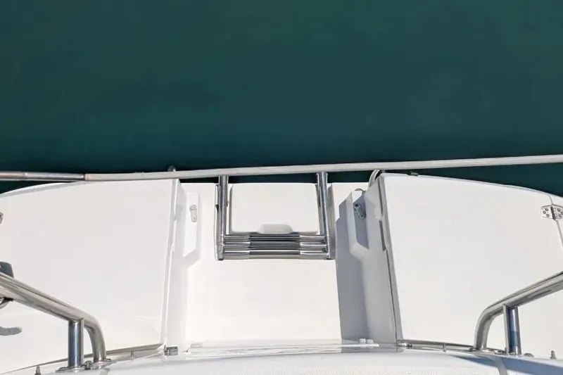 Slide: The Image of 1998 Hunter 34 boat deck with stainless steel ladder and railing, overlooking calm water. - 9