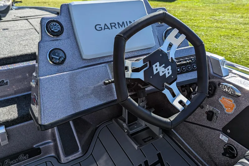 Slide: The Image of 2026 Bass Cat Cougar FTD SP boat dashboard with Garmin display and steering wheel. - 10