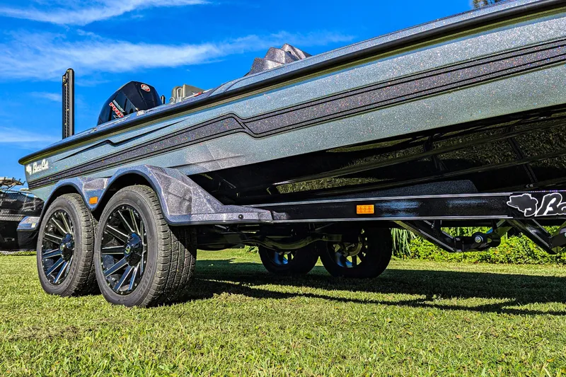 Slide: The Image of 2026 Bass Cat Cougar FTD SP boat on trailer, shiny finish, parked on grass. - 3