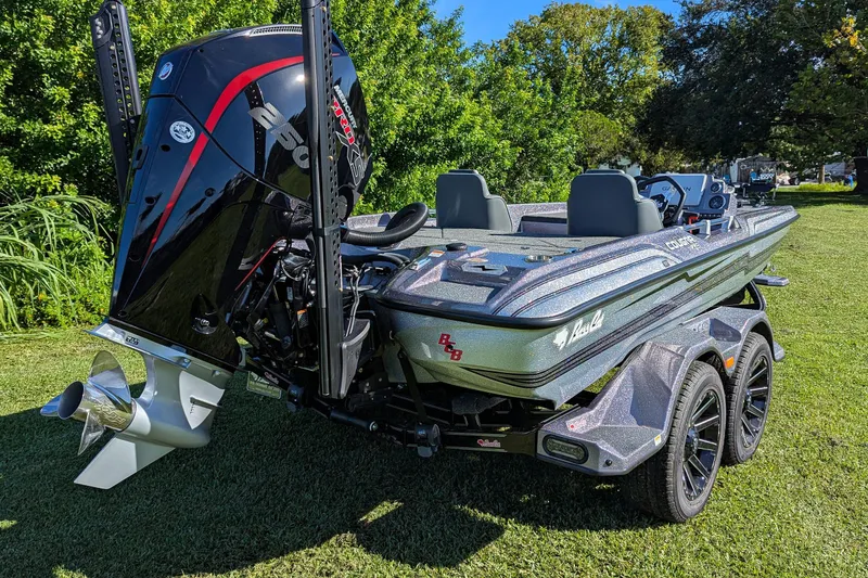 Slide: The Image of 2026 Bass Cat Cougar FTD SP boat with powerful engine, parked on grass. - 6