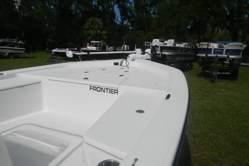 Slide: The Image of White 2016 Frontier 2104 boat on grass, surrounded by other boats. - 6