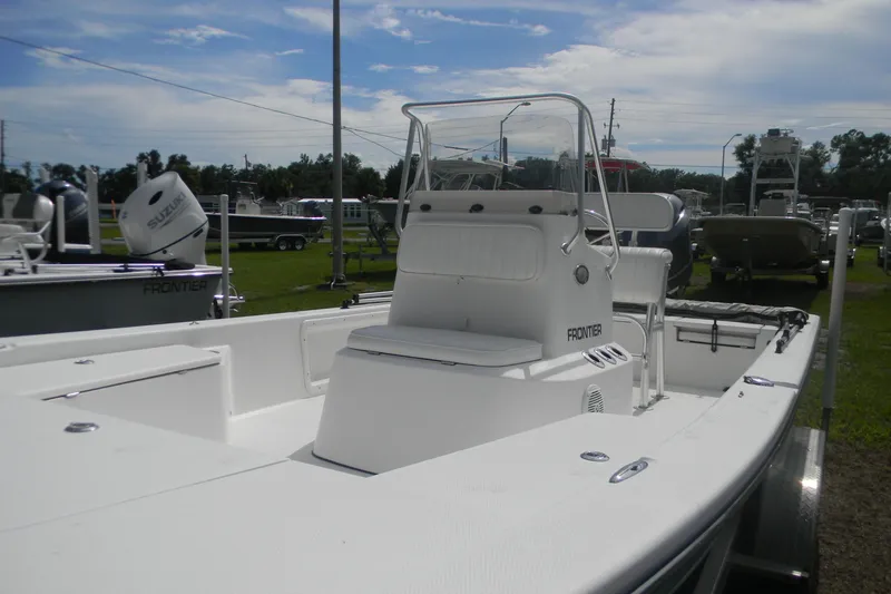 Slide: The Image of 2016 Frontier 2104 boat with center console, displayed outdoors under a partly cloudy sky. - 8