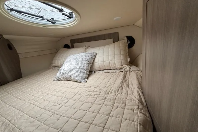 Slide: The Image of Cozy cabin interior of 2019 Regal 33 XO boat with plush bedding. - 12