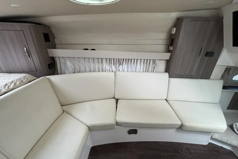Slide: The Image of Interior of 2019 Regal 33 XO yacht with white leather seating and wood cabinets. - 13