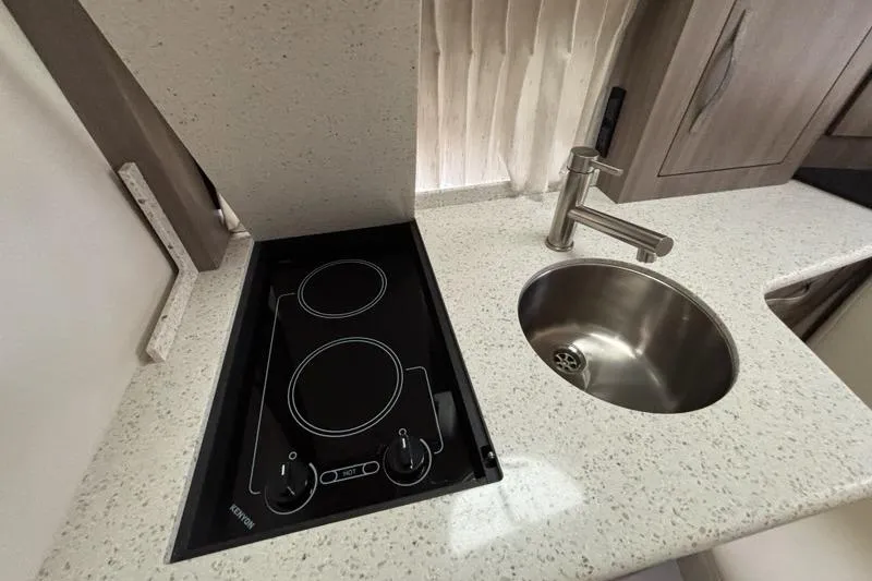 Slide: The Image of 2019 Regal 33 XO yacht kitchen with stovetop and round sink. - 17