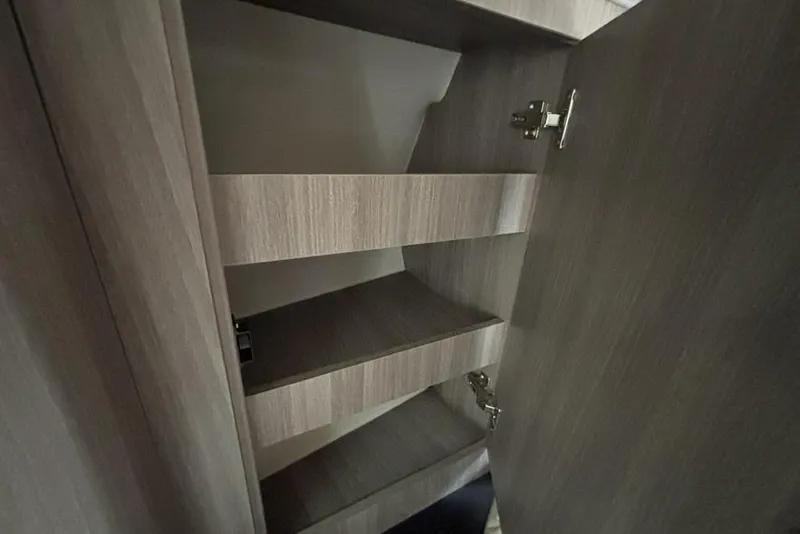 Slide: The Image of Interior shelving of 2019 Regal 33 XO boat, featuring wooden finish and adjustable shelves. - 19