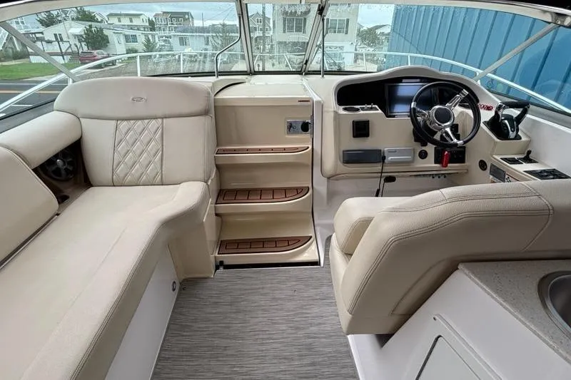 Slide: The Image of 2019 Regal 33 XO boat interior with beige seating and modern helm. - 2