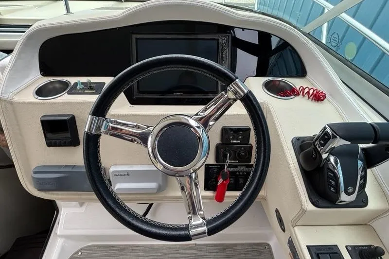 Slide: The Image of 2019 Regal 33 XO boat helm with steering wheel and control panel. - 6