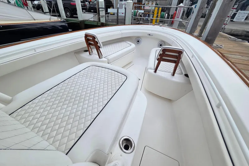 Slide: The Image of 2021 Valhalla Boatworks V-33 interior with white quilted seating at a marina. - 11