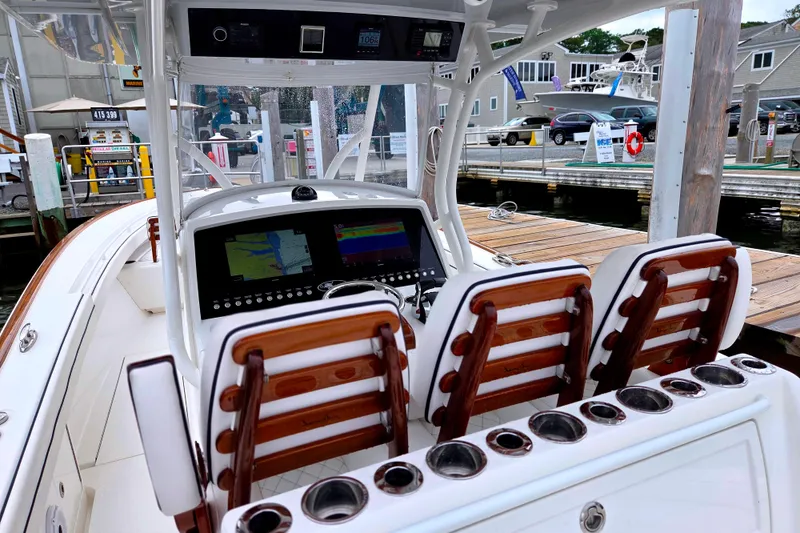 Slide: The Image of 2021 Valhalla Boatworks V-33 helm with advanced navigation displays at a marina dock. - 14