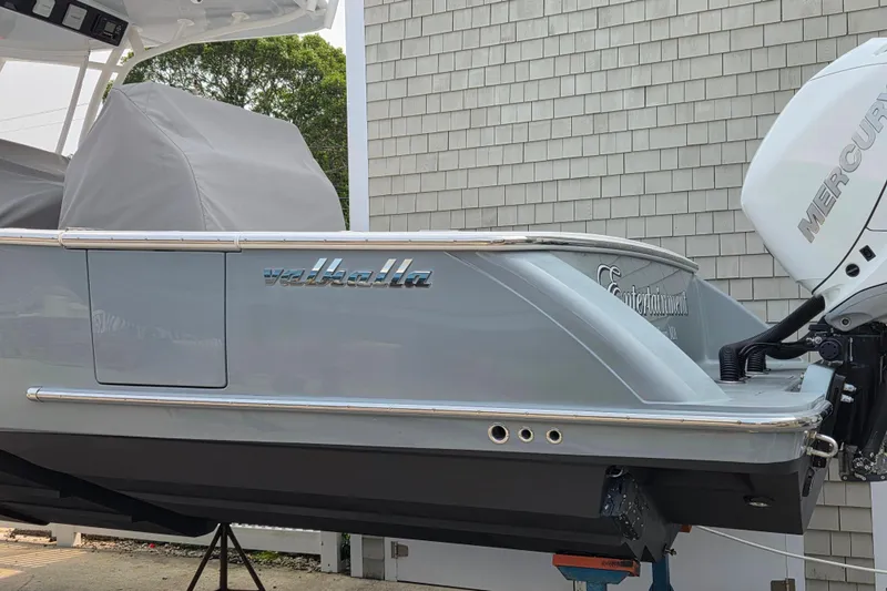 Slide: The Image of 2021 Valhalla Boatworks V-33 with Mercury engine, docked near a shingled building. - 23