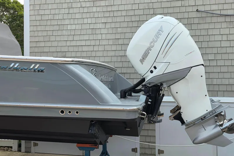 Slide: The Image of 2021 Valhalla Boatworks V-33 with Mercury outboard engine, docked near a shingled building. - 22