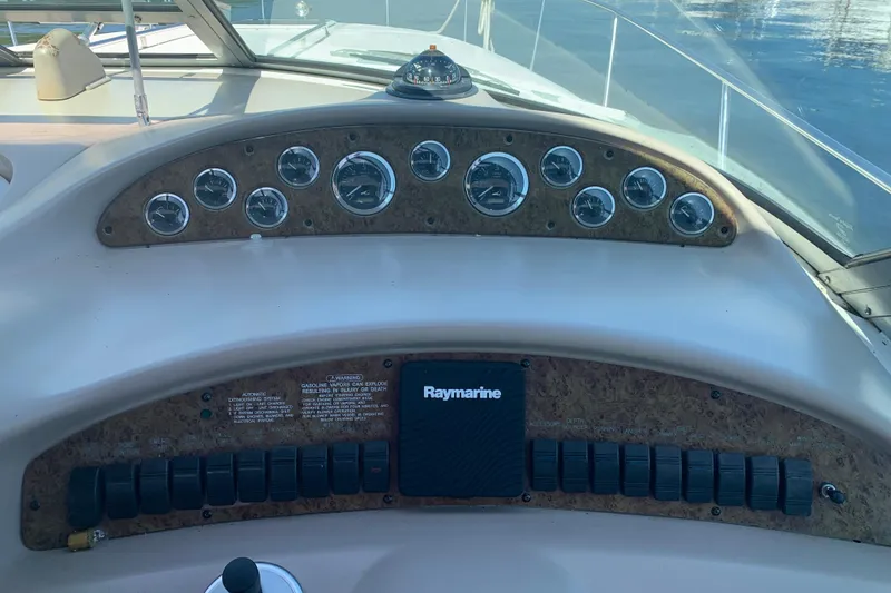 Slide: The Image of Dashboard of a 2001 Sea Ray 340 Sundancer boat with gauges and Raymarine equipment. - 11